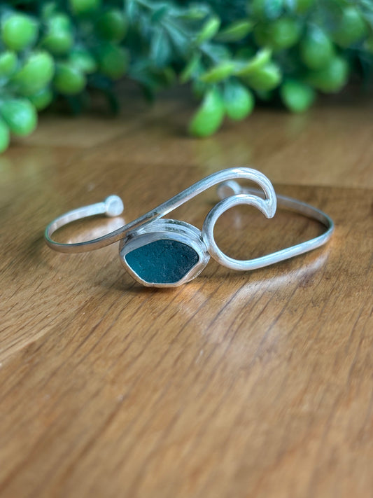 Brazalete con forma de ola del mar y pequeño cristal de mar azulado, engarzado, en plata 925
Diseño artesanal 