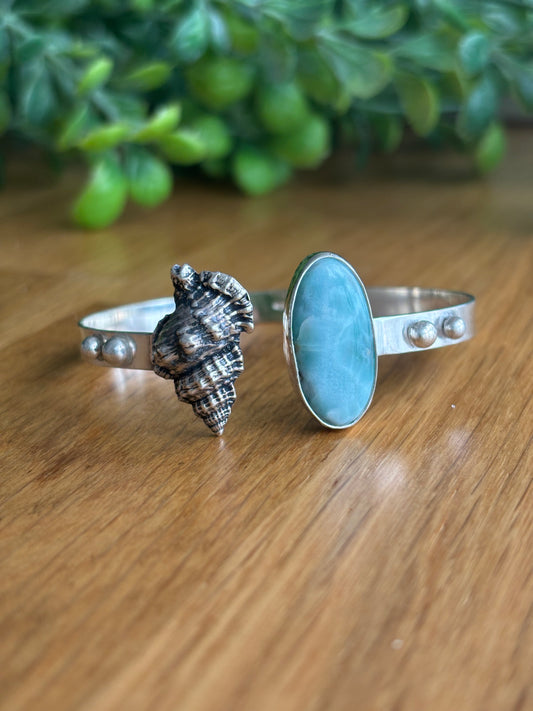 Brazalete con diseño de caracola en plata maciza en un extremo y con una piedra larimar engarzada en el otro extremo, plata 925
Diseño artesanal 